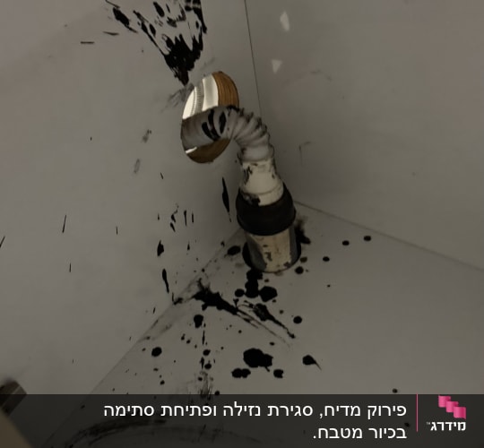 צינור מתכת עם כתמי נוזל שחור בארון